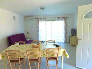 Un comedor con mesa y sillas y una sala de estar. en Maison confortable avec vue sur la mer et la montagne à Oletta., en Oletta