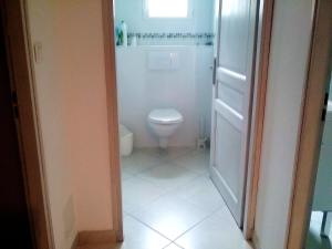 Un pequeño baño con inodoro y ventana. en Maison confortable avec vue sur la mer et la montagne à Oletta., en Oletta