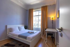 sypialnia z łóżkiem, biurkiem i oknem w obiekcie The Delight Hostel w Lizbonie