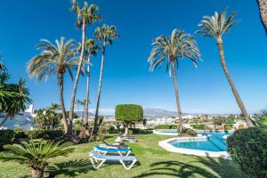 een resort met palmbomen en een zwembad bij P2B - Casa Paraiso by Roomservices in Estepona