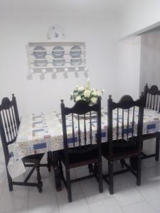 a dining room table with two chairs and a table with flowers on it at Casa Aires Varela in Elvas