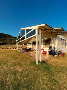 ein großes weißes Gebäude mit einer Terrasse auf einem Feld in der Unterkunft Tinton Hillstay in Chikmagalur