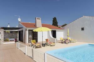 una casa con piscina e ombrellone giallo di Villa Jacaranda ad Albufeira