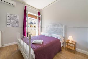 ローマにあるUn Attimo A Roma B&Bのベッドルーム(紫の毛布付きのベッド1台付)