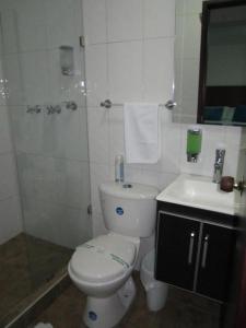 a bathroom with a toilet and a sink and a shower at Hotel Casa Lamay in Bogotá