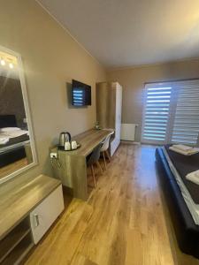 a room with a desk and a bed in it at Hotel Pod Strzechą in Kielce