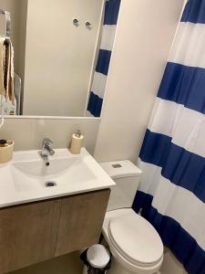 a bathroom with a sink and a toilet and a mirror at Cumbre de Reñaca II in Viña del Mar