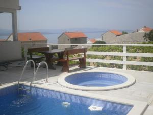 a swimming pool with a table and a picnic table on a balcony at Villa Ana in Bol