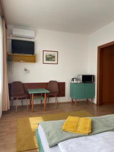 a room with a bed and a table and chairs at Hello Balcsi Apartmanház in Tihany