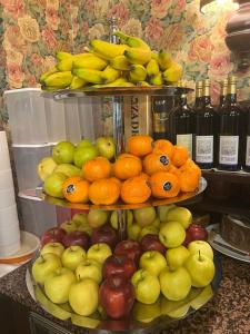 une exposition de pommes oranges et autres fruits sur une étagère dans l'établissement Villaggio Hotel Aquila, à Calliano