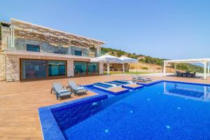 a villa with a swimming pool and a house at Villa Orient Platinum in Skinária
