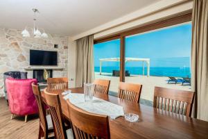 a dining room with a table and a view of the ocean at Villa Orient Platinum in Skinária