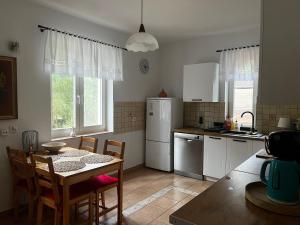 a kitchen with a table and a table and chairs at Mazury- dom wakacyjny in Pisz