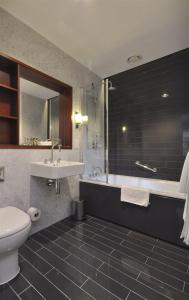 een badkamer met een toilet, een wastafel en een bad bij Downing College in Cambridge