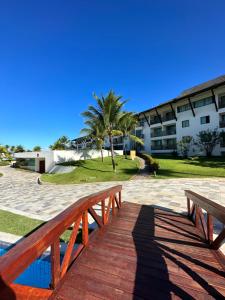 a wooden bridge over a pool in front of a building at Beach class muro alto in Porto De Galinhas