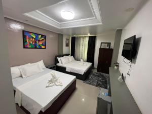 ein Hotelzimmer mit 2 Betten und einem TV in der Unterkunft Oceanlodge El Nido in El Nido