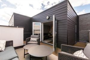 a patio with chairs and a table on a building at Super High End 1 bed with Balcony - Central West Bridgford in Nottingham