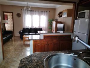 cocina y sala de estar con sofá y lavamanos en Villa Cantora, en Telde
