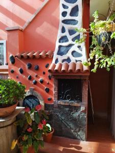un horno de pizza al aire libre en una casa con plantas en Villa Cantora, en Telde