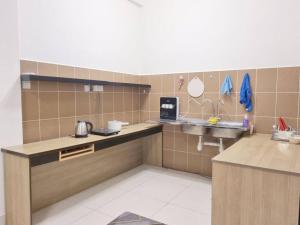uma cozinha com um balcão e um lavatório num quarto em Cozy Party Homestay nearby Airport em Sandakan