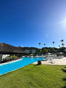 a resort with a large swimming pool next to a beach at Beach class muro alto in Porto De Galinhas