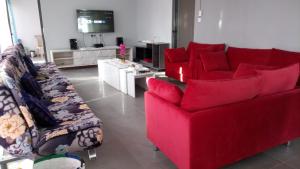 uma sala de estar com um sofá vermelho e duas cadeiras em KG Villa em Grand Baie