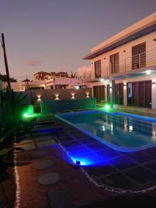uma piscina com luzes azuis ao lado de um edifício em KG Villa em Grand Baie