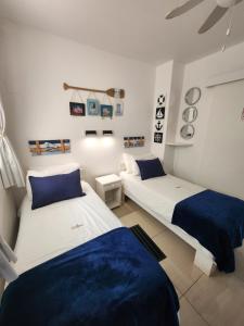 two beds in a room with blue and white at Driftsands Sea View Flats in Uvongo Beach +200 photos