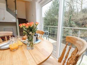 a dining room table with a vase of flowers on it at Riverbank View in Whitby