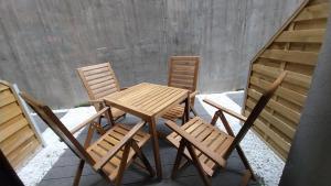 een houten tafel en stoelen op een patio bij Peaceful Basement Apartment with Terrace & free GYM in Boedapest