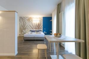 - une chambre avec un lit, une table et des chaises dans l'établissement Sporthotel Villa Stella, à Nago-Torbole