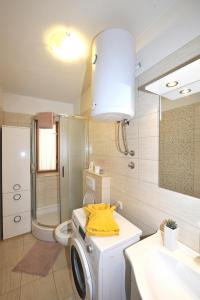 uma casa de banho com uma máquina de lavar roupa e um lavatório em Spalato em Split