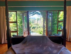 a bedroom with a bed and a large glass window at Timeless in Hogsback