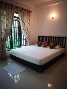 a bed in a room with a large window at Hotel Bird Paradise in Sigiriya