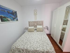 a small room with a bed and a mirror at VILLA PITATO Nuevo, cerca de la Playa, Parking en la puerta del alojamiento in Cala del Moral