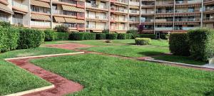 ogród przed dużym apartamentowcem w obiekcie Capitale du mimosa w mieście Mandelieu-la-Napoule