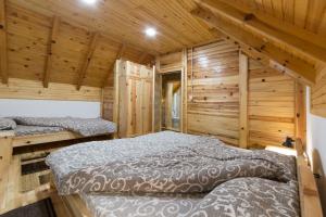 a bedroom with two beds in a wooden cabin at Stojanov Konak in Lazići