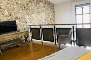 uma sala de estar com uma televisão e uma mesa com uma cadeira em Hermoso Loft en Valquirico, Lofts Frontana. em Tlaxcala de Xicohténcatl