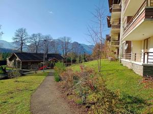 a path next to a house with mountains in the background at Hermoso departamento en condominio privado alicura in Pucón