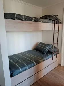 a bedroom with two bunk beds in a room at Hermoso departamento en condominio privado alicura in Pucón