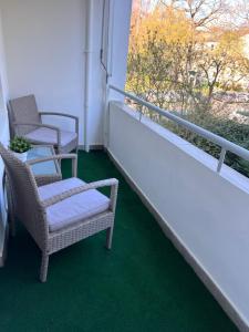 2 sillas y una mesa en un balcón con ventana en Family Apartment en Karlsruhe