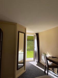 a room with a mirror and a table and a window at Hotel Inn Design Le Havre in Montivilliers