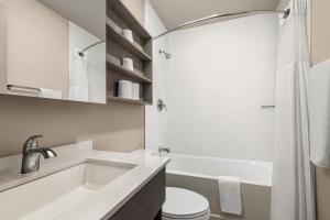 La salle de bains est pourvue d'un lavabo, de toilettes et d'une baignoire. dans l'établissement Microtel Inn & Suites by Wyndham Boisbriand, à Sainte-Thérèse-de-Blainville