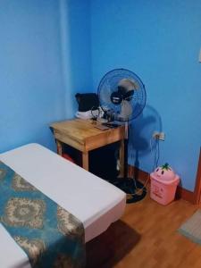 a room with a desk with a fan on a table at JayDin Travellers Inn in Panglao