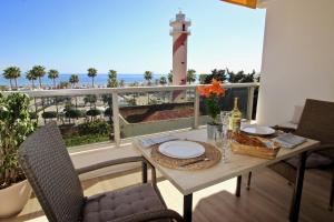 een eettafel met uitzicht op een vuurtoren op een balkon bij New 1 Bedroom Apartment with FANTASTIC views RDR284 in Marbella