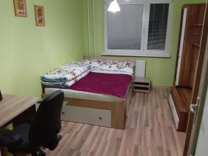 um pequeno quarto com uma cama, uma secretária e uma cadeira em Krásny byt, Košice, Juhoslovanska1. Ťahanovce em Košice