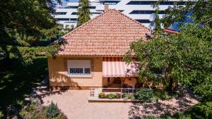 una pequeña casa con techo rojo en un patio en Szemes Villa, en Balatonszemes