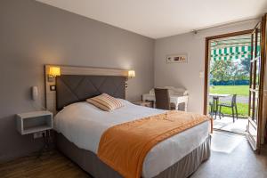a bedroom with a bed and a balcony with a table at Hotel Village Motel in Tournus +93 photos