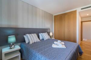 a bedroom with a blue bed with towels on it at Vilamoura Sun Aquamar 503 in Quarteira