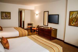 um quarto de hotel com duas camas e uma televisão de ecrã plano em Lidotel San Cristóbal em San Cristóbal
